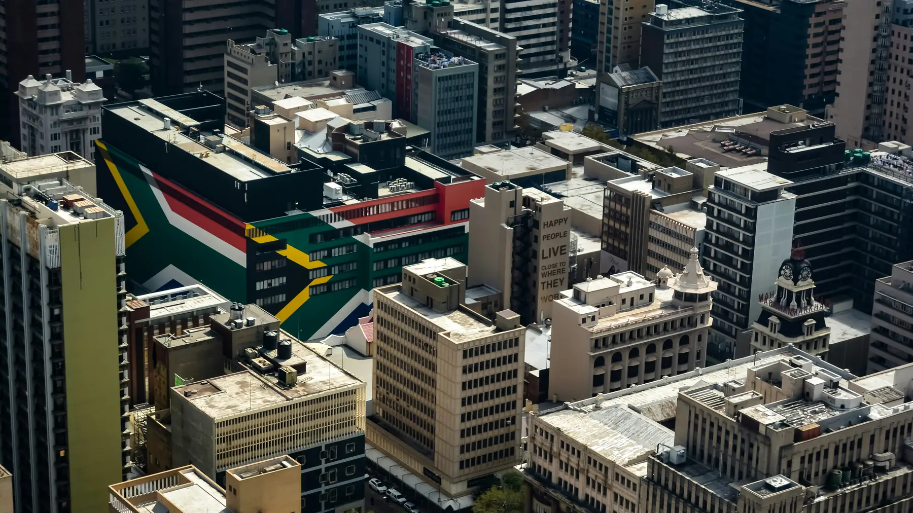 An aerial view over the Johannesburg city centre, South Africa, with the South African flag painted across one rooftop.